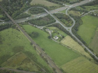 Oblique aerial view centred on the site of the Roman fort and Roman road, taken from the ESE.