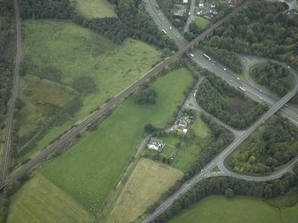 Oblique aerial view centred on the site of the Roman fort and Roman road, taken from the NE.