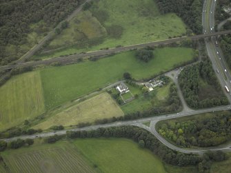 Oblique aerial view centred on the site of the Roman fort and Roman road, taken from the N.