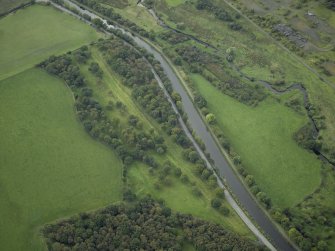 Oblique aerial view centred on the site of the Roman fortlet and the course of the Antonine Wall and the Military Way with the canal and aqueduct adjacent, taken from the E.