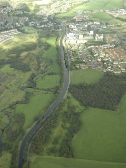 General oblique aerial view centred on the site of the Roman fortlet and the course of the Antonine Wall and the Military Way with the canal and aqueduct adjacent, taken from the SW.