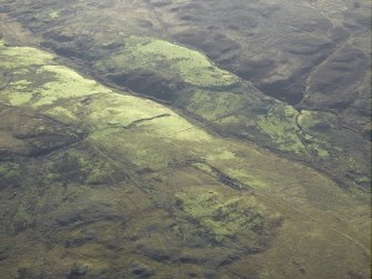 General oblique aerial view centred on the remains of the farmstead, chapel, enclosure, townships, rig and lazy beds, taken from the N.