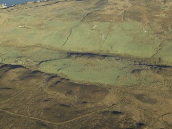 General oblique aerial view centred on the remains of the farmstead, chapel, enclosure, townships, rig and lazy beds, taken from the SSW.