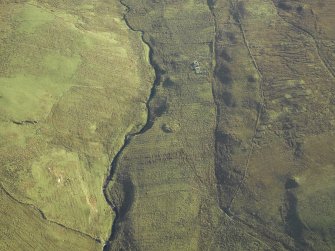 Oblique aerial view centred on the remains of the farmstead and chapel with the remains of the building adjacent, taken from the WNW.