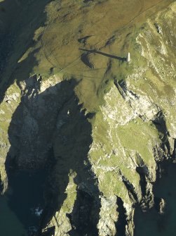 Oblique aerial view centred on the monument and entrance to the cave, taken from the SW.