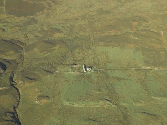 Oblique aerial view centred on the remains of the township and field-system and the farmhouse and farmsteading, taken from the SE.