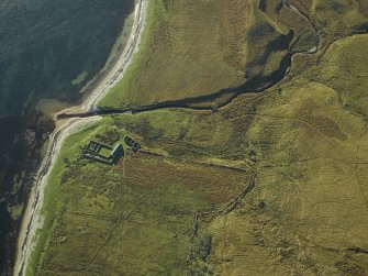 Oblique aerial view centred on the remains of the cottage, rig and sheepfold, taken from the NNE.