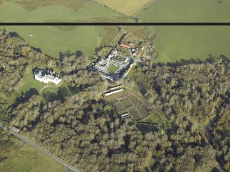 General oblique aerial view centred on the country house, kennels, cottage, farmsteading, byre, farmhouse and walled garden, taken from the SSW.