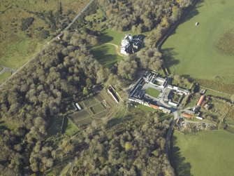 General oblique aerial view centred on the country house, kennels, cottage, farmsteading, byre, farmhouse and walled garden, taken from the E.