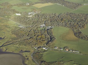 General oblique aerial view centred on the village with the church in the foreground and the country house in the distance, taken from the SSW.