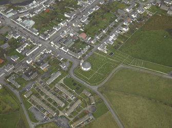 General oblique aerial view of the village centred on the church, taken from the SW.