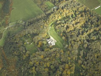 Oblique aerial view centred on the country house and walled garden with the remains of the church and burial-ground adjacent, taken from the WSW.