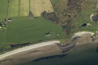 Obique aerial view centred on the remains of the chapel, burial ground and bombing range marker, taken from the SW.