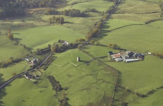 Oblique aerial view centred on the remains of the tower-house and rig with the farmstead adjacent, taken from the E.