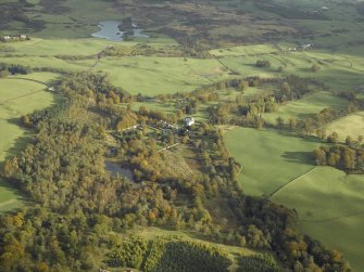 General oblique aerial view centred on the country house, stables and walled garden, taken from the W.