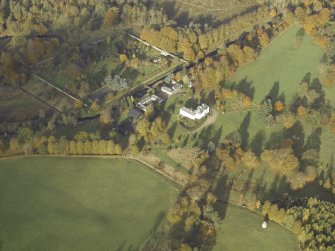 Oblique aerial view centred on the country house, stables and walled garden, taken from the SSE.