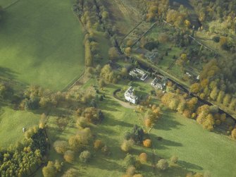 Oblique aerial view centred on the country house, stables and walled garden, taken from the NE.