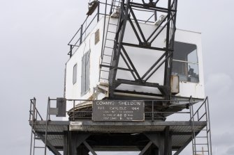 Detail.  Crane on E pier showing  cab, makers nameplate and lower part of jib.