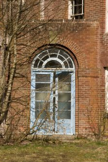 Detail. E entrance doorway on main Sandhurst Barrack Block showing round arch over door and metal framing with glazing bars on door.