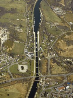 Oblique aerial view centred on the canal at Neptune's Staircase, canal basin, locks, swing bridges and railway bridge, taken from the SW.