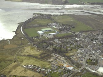 General oblique aerial view of the town centred on the hospital, football ground and stadium with the churches adjacent, taken from the NNW.