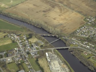 Oblique aerial view centred on the road bridge, railway viaduct and pipe bridge, taken from the ENE.