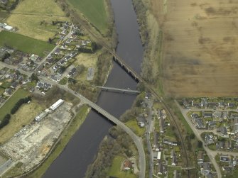 Oblique aerial view centred on the road bridge, railway viaduct and pipe bridge, taken from the N.