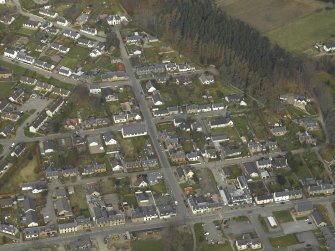 Oblique aerial view of the village centred on the church, taken from the SE.