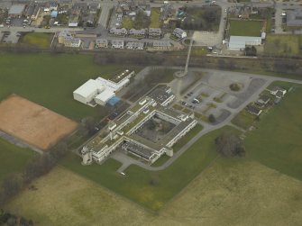 Oblique aerial view centred on the school and the footbridge, taken from the SSW.