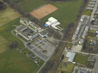 Oblique aerial view centred on the school and the footbridge, taken from the E.