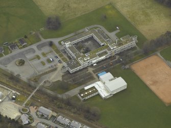 Oblique aerial view centred on the school and the footbridge, taken from the N.