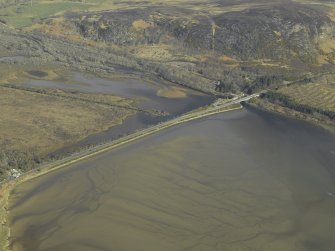 General oblique aerial view centred on the causeway and road bridge with the railway station adjacent, taken from the S.