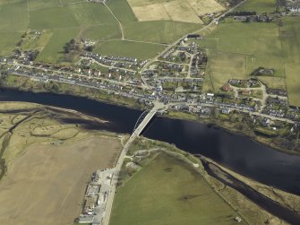 Oblique aerial view of the village centred on the road bridge with the hotel adjacent, taken from the SW.