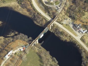 Oblique aerial view centred on the railway viaduct with the railway station adjacent, taken from the SW.