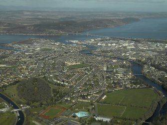 General oblique aerial view of the town centred on Inverness High School with Kessock Bridge in the distance and the park and the cemetery in the foreground, taken from the SW.