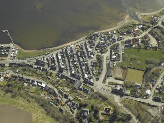 Oblique aerial view of the village centred on the church, road bridge and hotel, taken from the NNW.