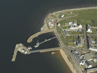 Oblique aerial view centred on the harbour and the lighthouse, taken from the SSW.