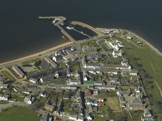 Oblique aerial view of the town centred on the harbour and lighthouse, taken from the SE.