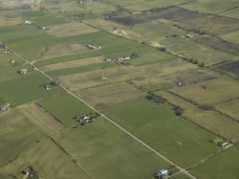 General oblique aerial view of the village centred on the pattern of dispersed buildings and layout of regular fields, taken from the W.