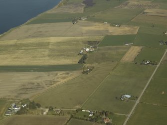 General oblique aerial view of the village centred on the pattern of dispersed buildings and layout of regular fields, taken from the SW.