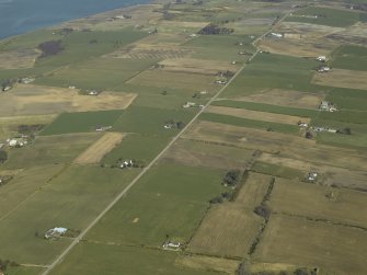 General oblique aerial view of the village centred on the pattern of dispersed buildings and layout of regular fields, taken from the SSW.