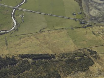 Oblique aerial view centred on the remains of the township and field-system with the road bridges, farmhouse and farmsteading adjacent, taken from the ENE.