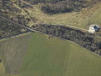 Oblique aerial view centred on the remains of the henge, taken from the N.