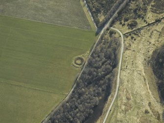 Oblique aerial view centred on the remains of the henge, taken from the W.