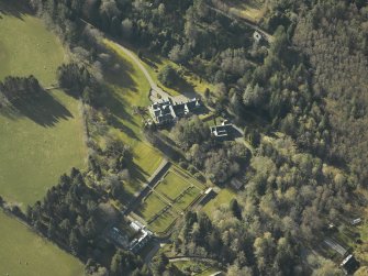 Oblique aerial view centred on the country house, gardens and cottages, taken from the NNW.