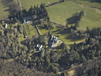 Oblique aerial view centred on the country house, gardens and cottages, taken from the SW.
