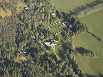 Oblique aerial view centred on the country house, gardens and cottages, taken from the SE.