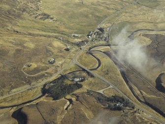 General oblique aerial view centred on the shooting lodge, railway bridge, road bridges and the hotel with the village in the distance, taken from the WSW.