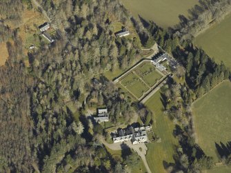 Oblique aerial view centred on the country house, cottages and walled garden, taken from the SE.