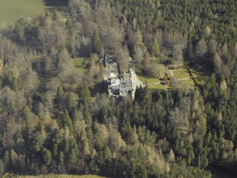 Oblique aerial view centred on the country house, formal garden and stables, taken from the SW.